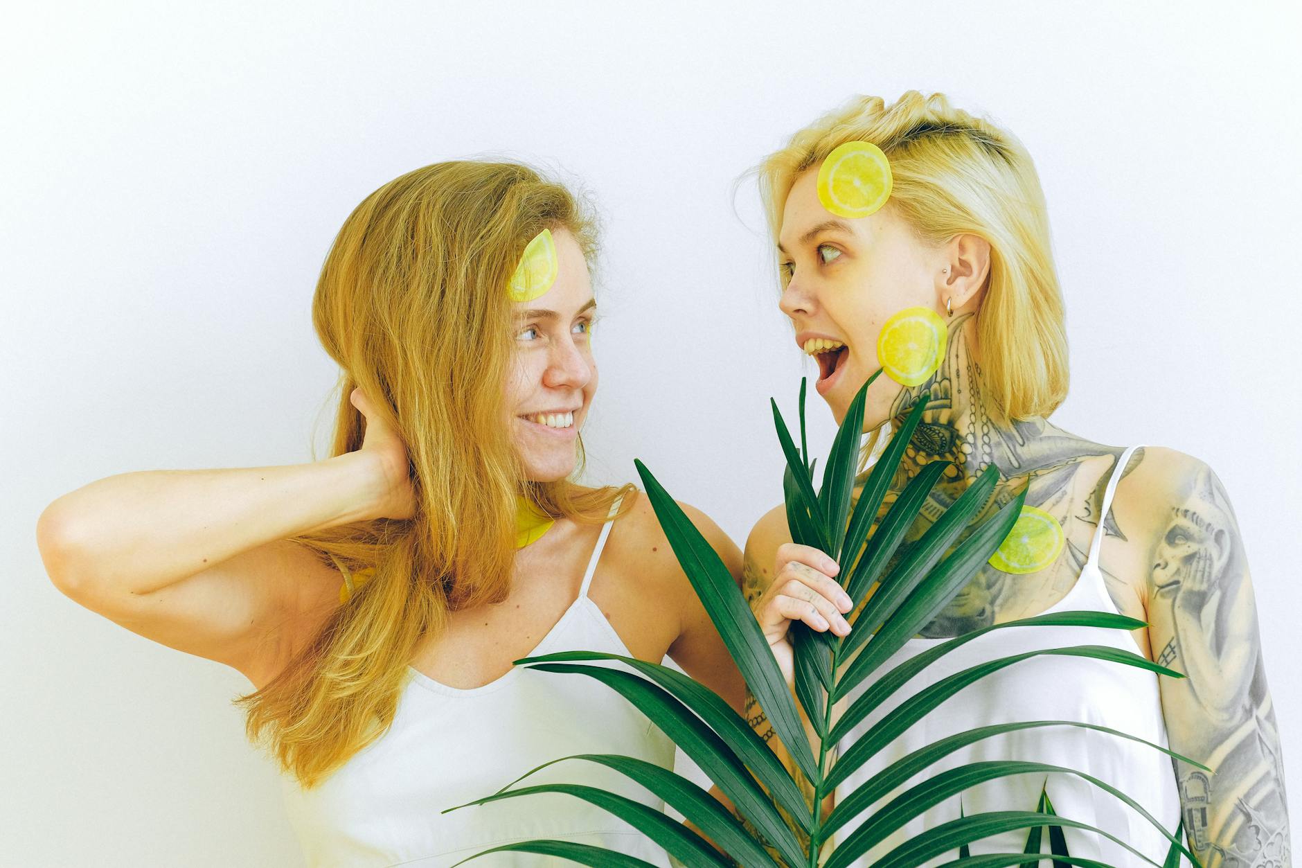 Due donne sorridenti con fette di limone, che esprimono gioia e serenità nell'intimità